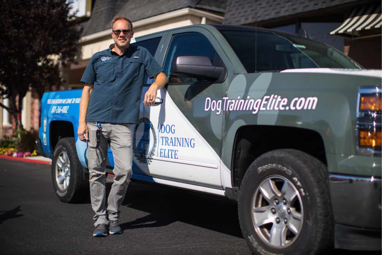 A member of Dog Training Elite's corporate team with a Dog Training Elite truck.