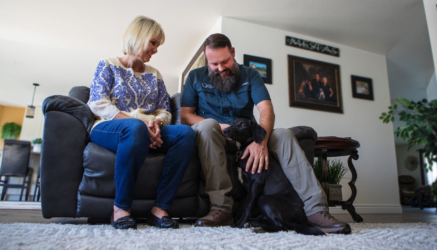 A pet owner and Dog Training Elite of Southwest Florida expert providing in-home training for a pup.