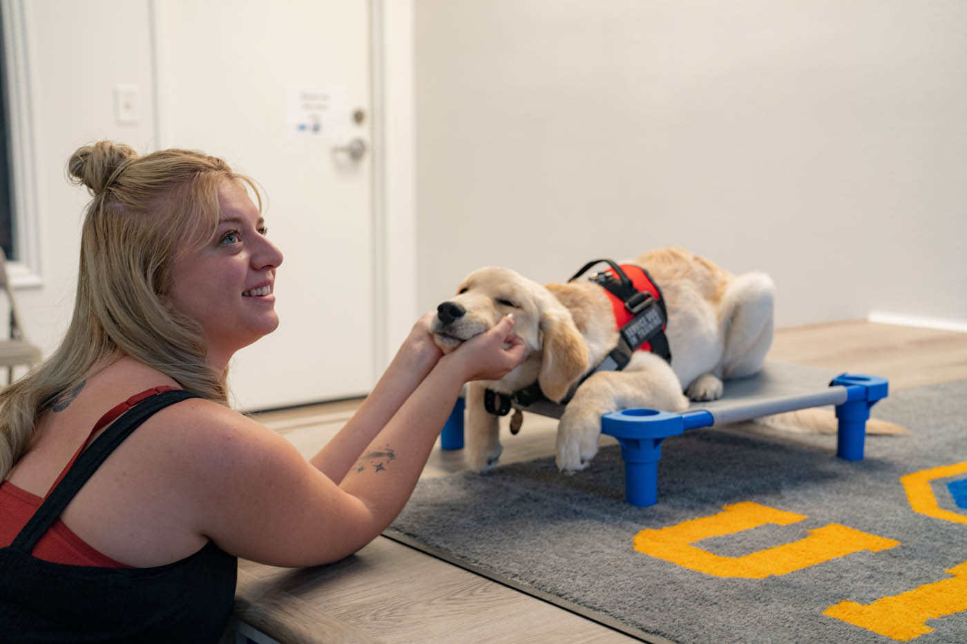 A dog owner and her service puppy - we are dedicated to using positive reinforcement in all of the training programs offed by our {surroudning_name} dog trainers.