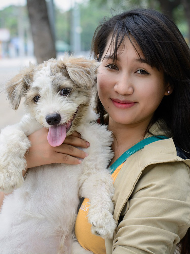 This pet-lover and franchise owner snuggles up with her dog, knowing Dog Training Elite is there to support her franchise.