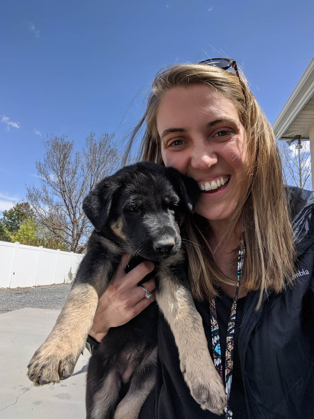 An image of a girl holding her puppy at home - discover the benefits of Baltimore / Towson  in house puppy training with Dog Training Elite.