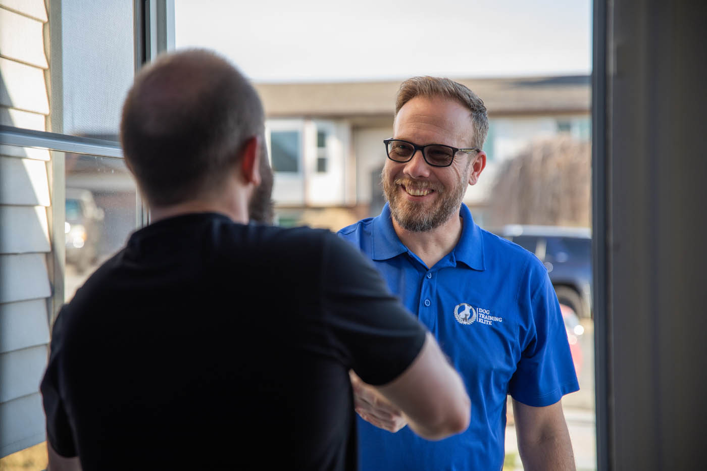 A Dog Training Elite owner gretting a dog owner at the door in Colorado Springs, CO.